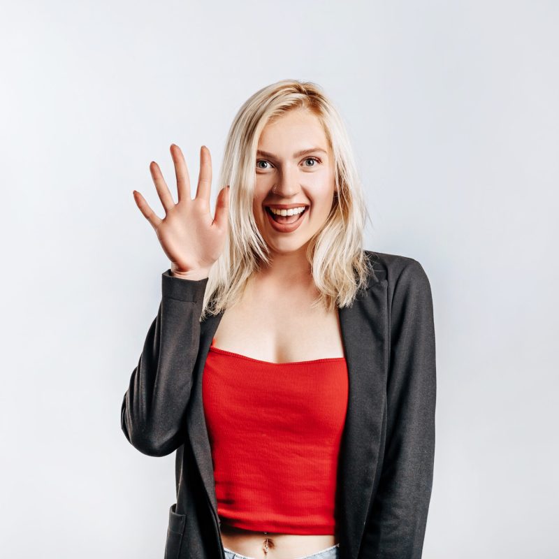 Beautiful happy young girl smiles on gray isolated background